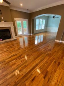 Imbue Cleaning Solutions worker showing a pic of wood floor with a new coat of polyurethane which have the floors looking new and shiny again this apart of our wood floor cleaning program