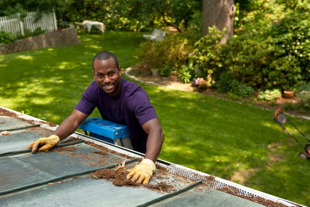 Imbue Cleaning Solutions worker providing gutter cleaning services on a house