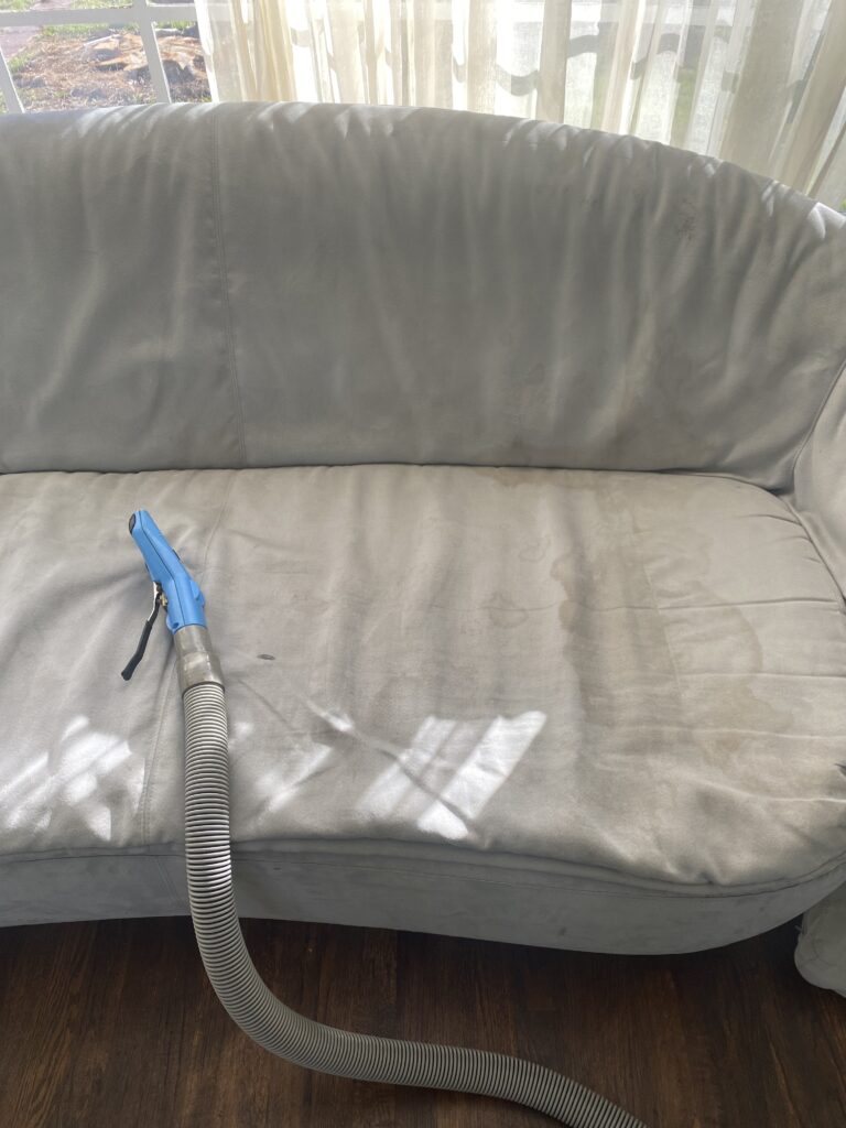 imbue cleaning solutions worker cleaning a dirty sofa which is apart of our upholstery cleaning services program